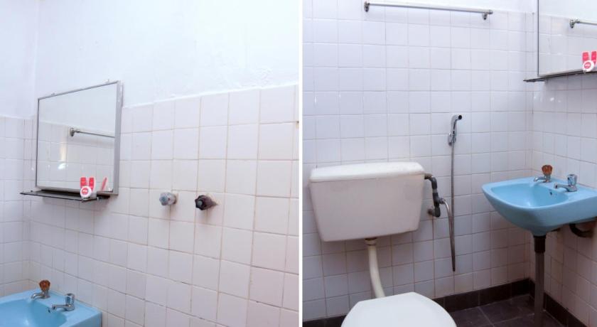 a bathroom with a toilet, sink and mirror, OYO 1173 Mandyrin Hotel in Sibu