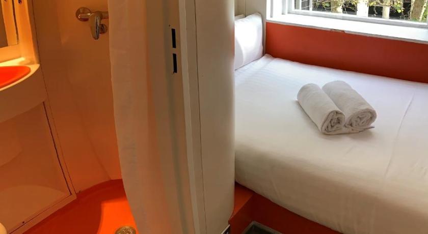 a room with a bed and a window, Easyhotel South Kensington in London