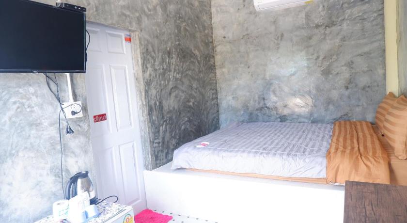 a bedroom with a bed and a television in it, Baanpak Jomyutt Suan Phueng in Ratchaburi