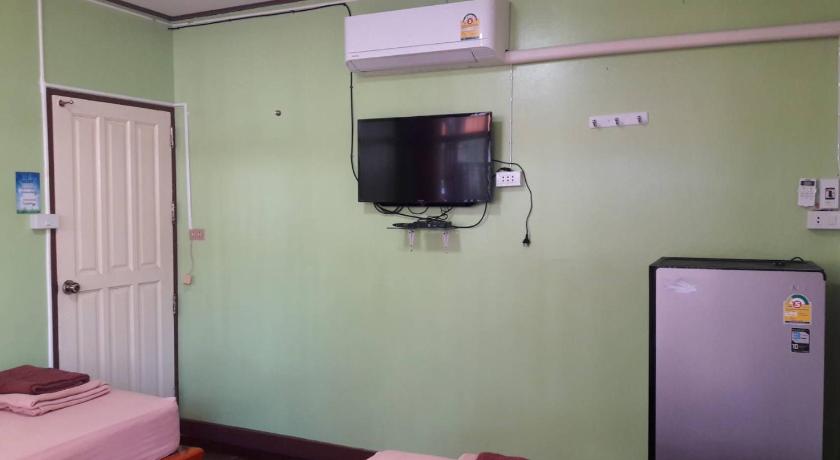 a television is on in a room with a blue wall, Punnpannsuk in Trat