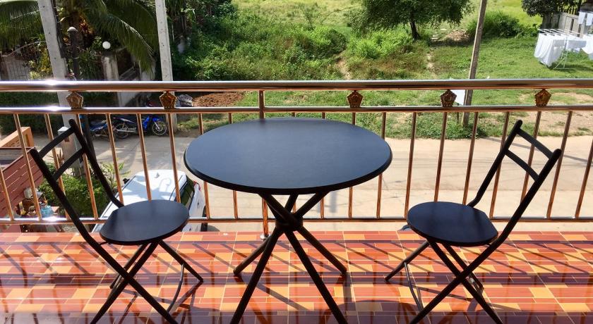 a table with chairs and umbrellas on a patio, Pantip Residence in Nan