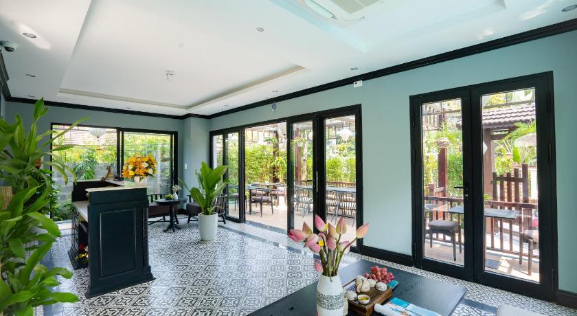 a living room filled with furniture and a large window, Daisy An Bang Villa in Hoi An