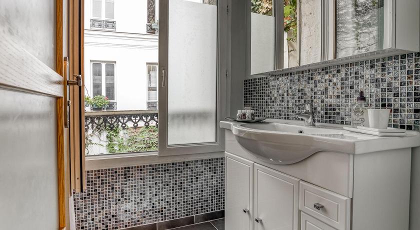a white sink sitting under a window in a bathroom, Une maison comme un Riad in Paris