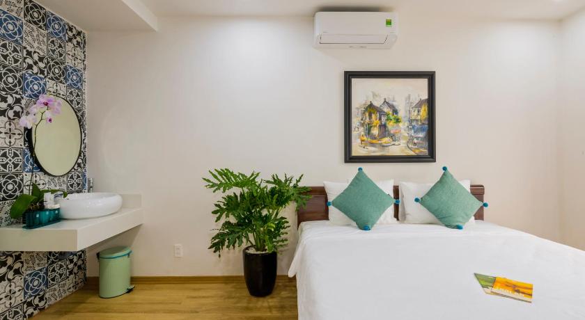 a room with a bed, a table, and a painting on the wall, Onion Homestay in Hoi An