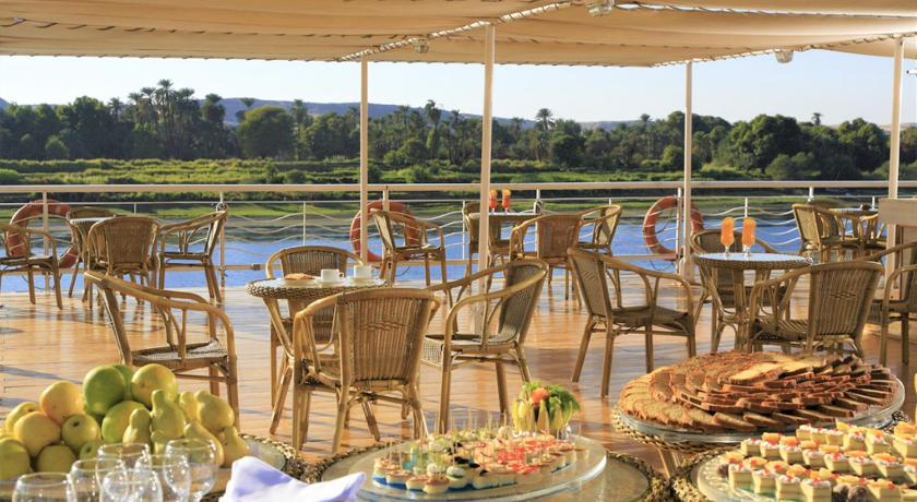 a patio area with tables, chairs and umbrellas, Iberotel Crown Empress Nile Cruise - Every Monday from Luxor for 07 & 04 Nights - Every Friday From  in Luxor