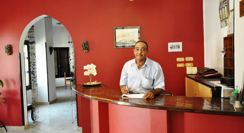 a man sitting at a counter in a restaurant, El Nakhil Hotel in Luxor