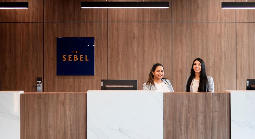a woman standing next to a man in front of a wall, The Sebel Canberra Civic in Canberra