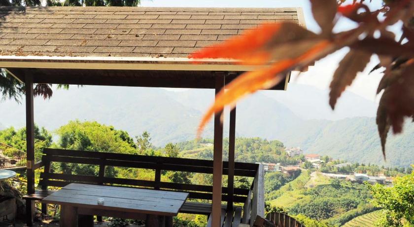 a wooden bench sitting on top of a lush green hillside, 5KM Villa in Nantou