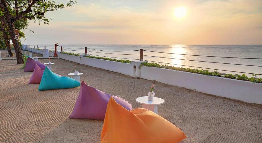 a beach area with chairs and umbrellas on the sand, Discovery Kartika Plaza Hotel in Bali