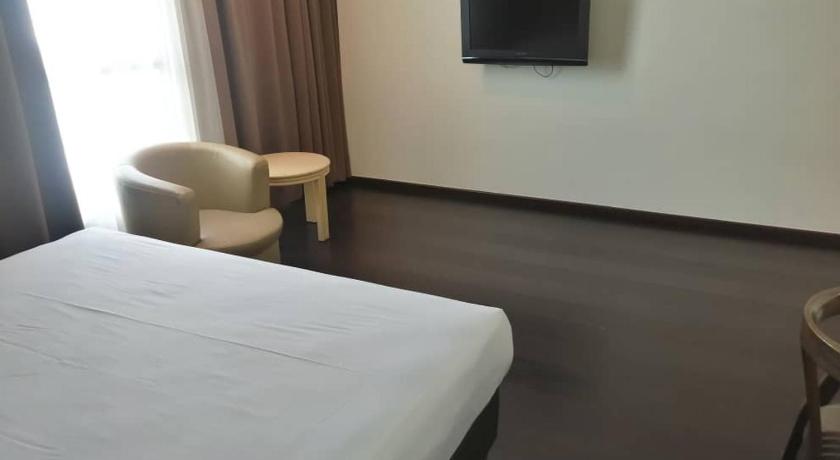 a hotel room with a bed and a television, Manja Hotel in Kota Kinabalu