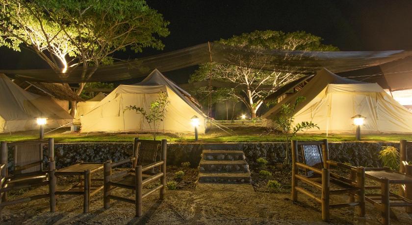 an outdoor area with benches and a tree, The Acacia Glamping Park in Bohol