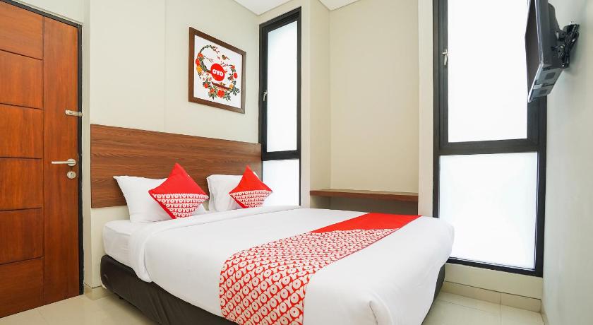 a hotel room with a bed and a desk, Super OYO 449 The Colins in Surabaya