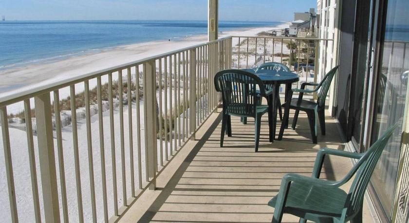 a patio area with chairs, tables, and umbrellas, Gulf Village by Bender Vacation Rentals in Gulf Shores (AL)