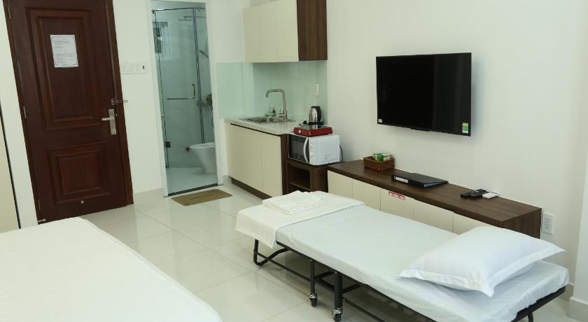 a hotel room with a bed and a television, Aladdin Hotel in Ho Chi Minh City
