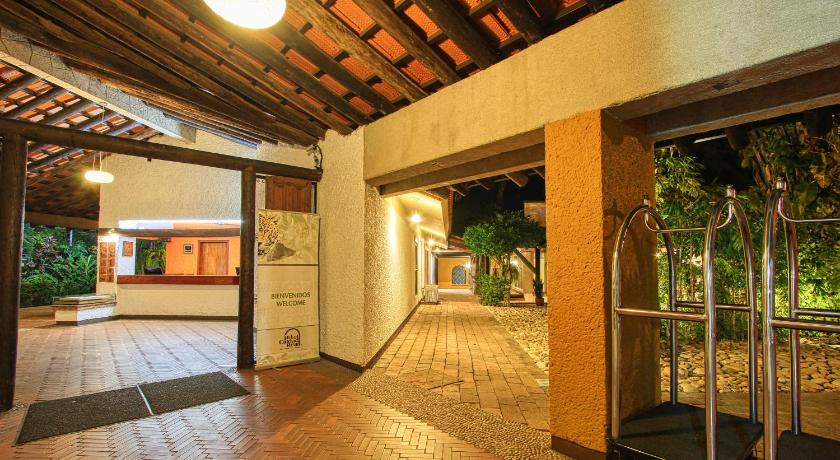a large room with a walkway leading to a building, Hotel Ciudad Real Palenque in Palenque