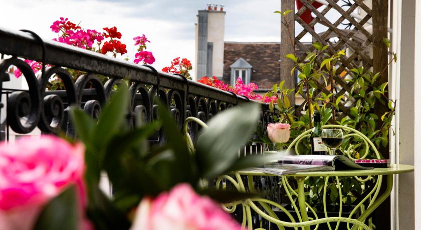 a vase filled with flowers next to a fence, Hotel Britannique in Paris