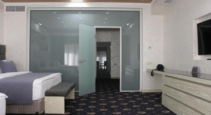 a bedroom with a bed and a dresser, Erebuni Hotel Yerevan in Yerevan