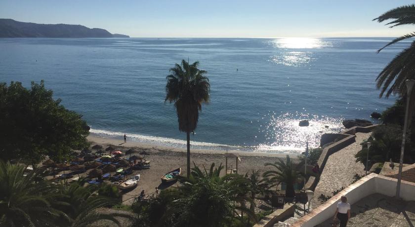a beach with palm trees and palm trees, Nerja Paradise Rentals in Nerja