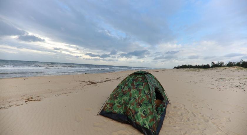 a tent on the beach with a person laying on it, Ocean View Homestay in Đồng Hới (Quảng Bình)