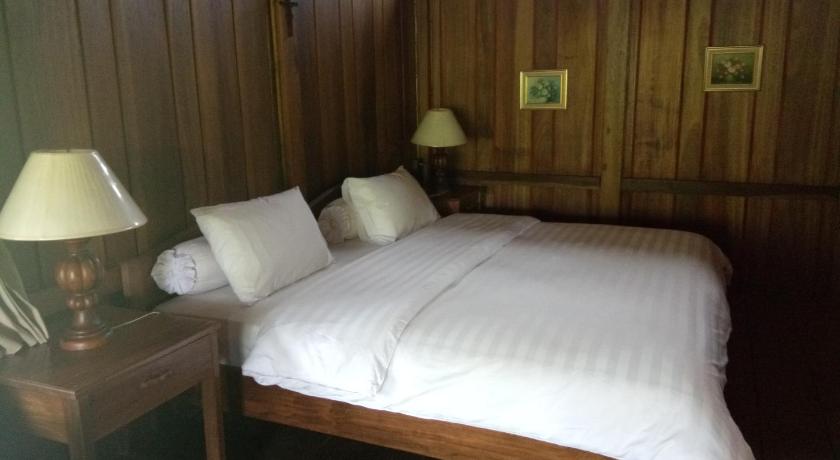 a neatly made bed in a hotel room, Gardenia Country Inn in Manado