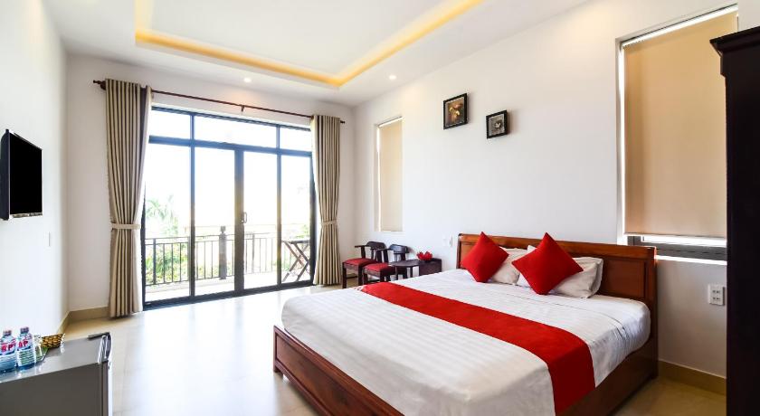 a bedroom with a large bed and a large window, OYO 473 Suburban Villa in Hoi An