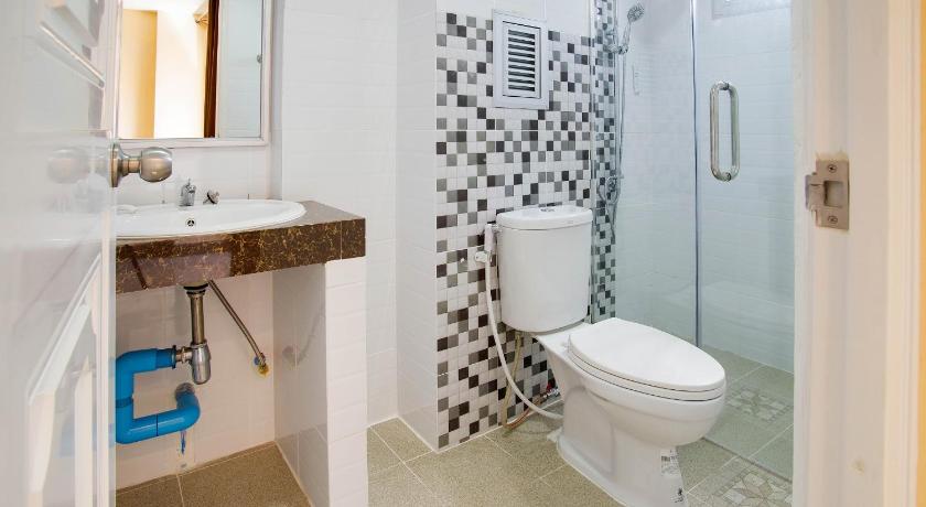 a bathroom with a toilet a sink and a shower, Wises Hotel in Chachoengsao