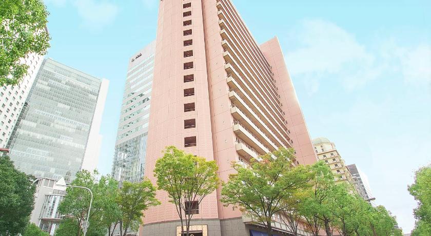 a tall building with a clock on the top of it, Hearton Hotel Nishi Umeda in Osaka