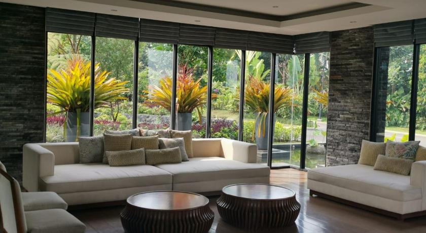 a living room filled with furniture and a large window, Vimala Hills Resort Cozy Villa Puncak Gadog Bogor in Puncak
