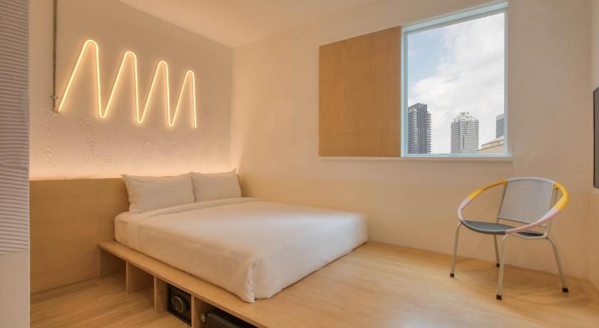a hotel room with a bed and a desk, MoMo's Kuala Lumpur in Kuala Lumpur