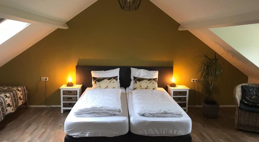 a bedroom with a bed and a lamp on the wall, B&B de Rivierduin in Hattem