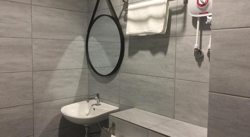 a bathroom with a sink, toilet and mirror, Urban Inn Alor Setar in Alor Setar