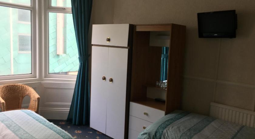 a bedroom with a bed and a dresser, Walford Hotel in Blackpool