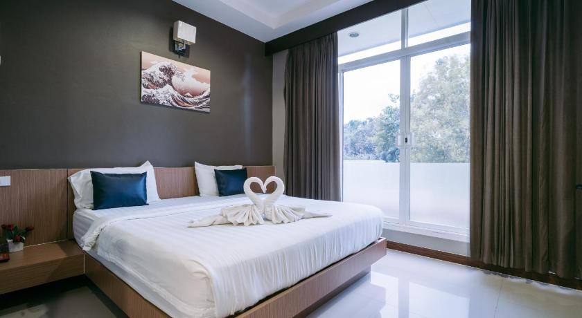 a bedroom with a large bed and a large window, Jintana Resort in Buriram