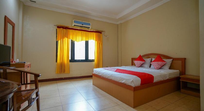 a bedroom with a bed and a window, OYO 1273 Hotel Belvena in Palembang
