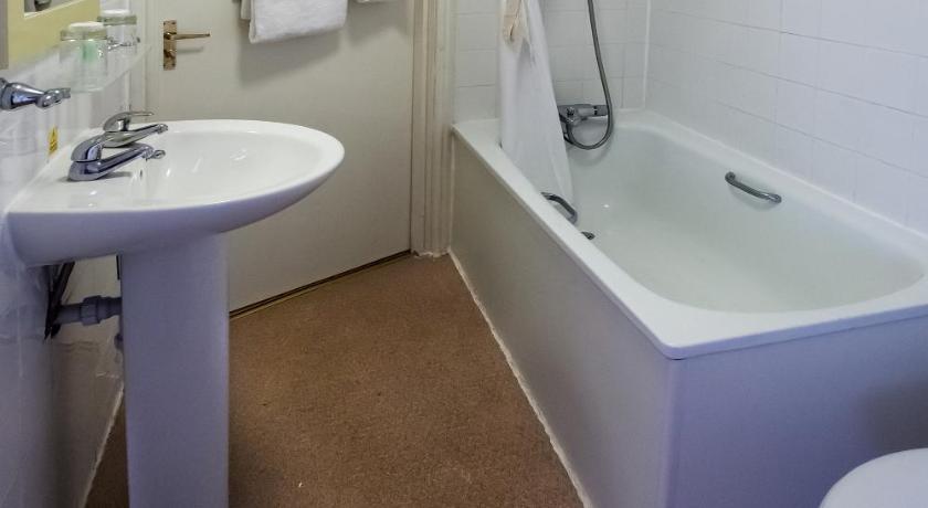 a bathroom with a sink, toilet and bathtub, Heathlands Hotel Bournemouth in Bournemouth
