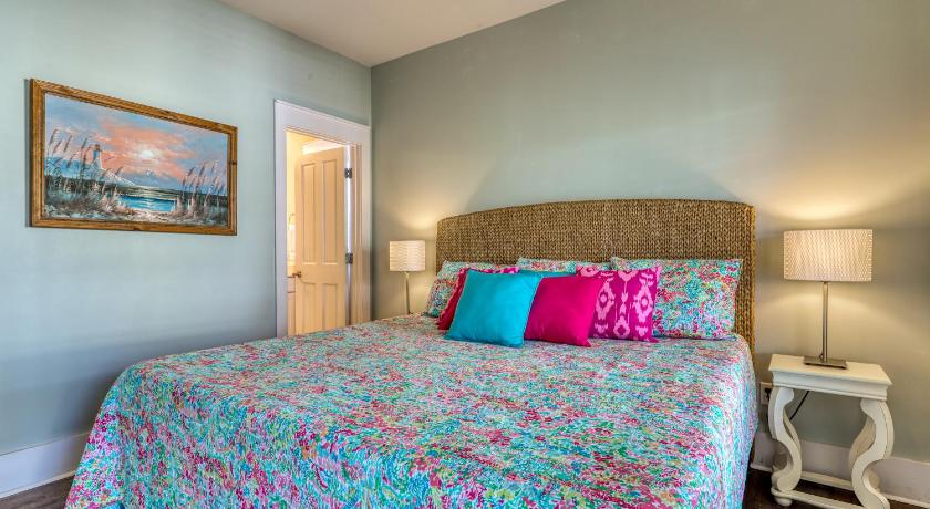 a bedroom with a bed, a dresser and a painting on the wall, Barefoot Cottages #C56 in Port Saint Joe