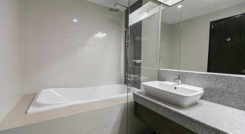 a bathroom with a tub, sink and mirror, La Maja Rica Hotel in Tarlac