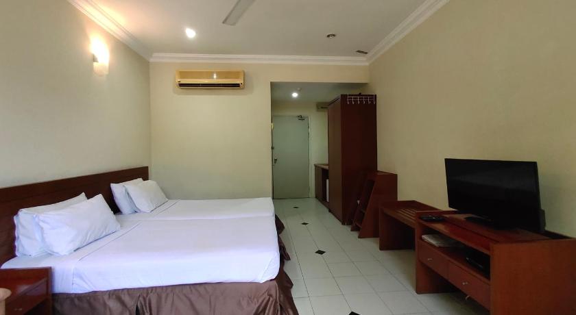 a hotel room with a bed and a television, Wawa Golf View Inn in Taiping