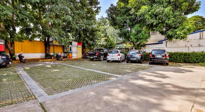 cars parked in a parking lot next to a fence, OYO 412 7 Days Hotel in Chiang Mai