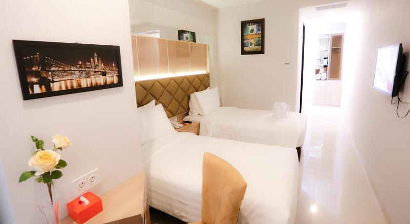a hotel room with two beds and a television, Daily Inn Hotel Jakarta in Jakarta