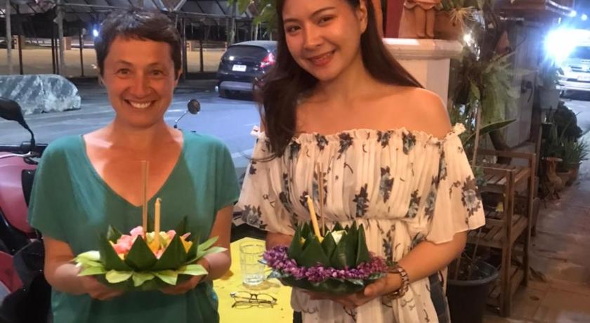a woman holding a bouquet of flowers standing next to a woman holding a, Benya Guest House in Nakhonratchasima