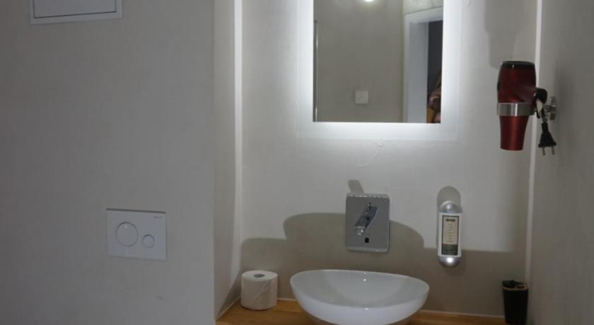 a bathroom with a toilet, sink, and mirror, Walhalla Aparthotel-Potsdam in Potsdam