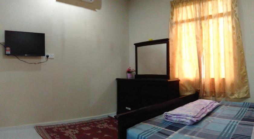 a bedroom with a bed and a television, ROOMSTAY AQILAH PASIR PUTEH KELANTAN in Pasir Putih