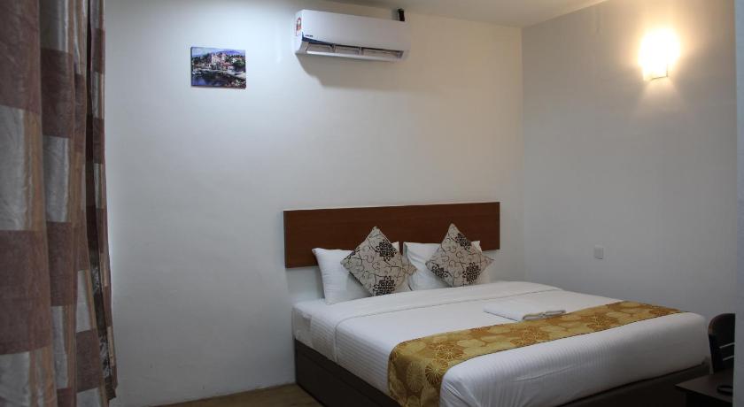 a hotel room with two beds and a lamp, Big Apple Hotel in Kulim