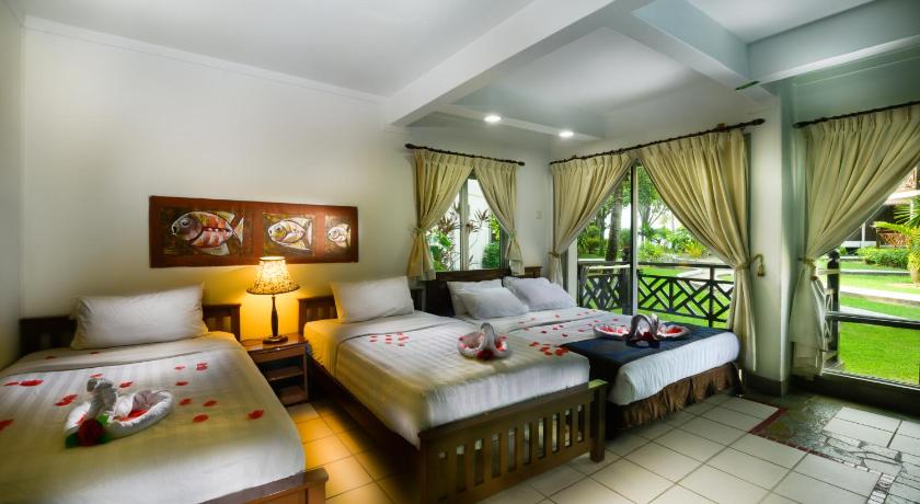a hotel room with two beds and a large window, Paya Beach Spa & Dive Resort in Tioman Island