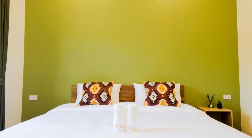 a bed with a white comforter and two pillows, The Cozy Hotel in Phetchaburi