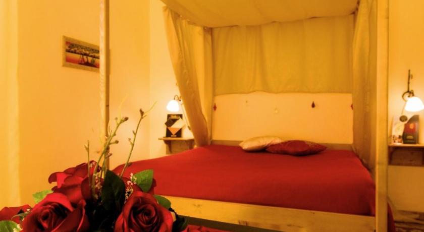 a bed in a room with flowers on it, Olympo in Bisceglie