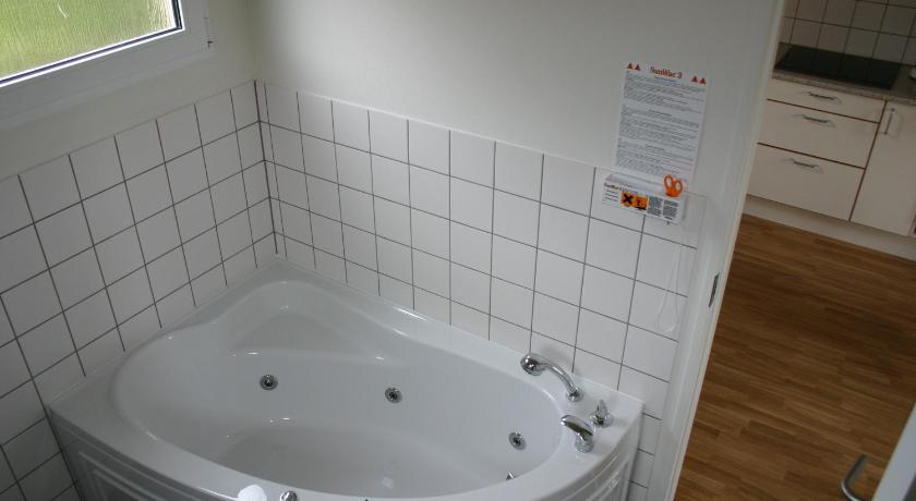 a white bath tub sitting inside of a bathroom, Esbjerg Camping in Esbjerg