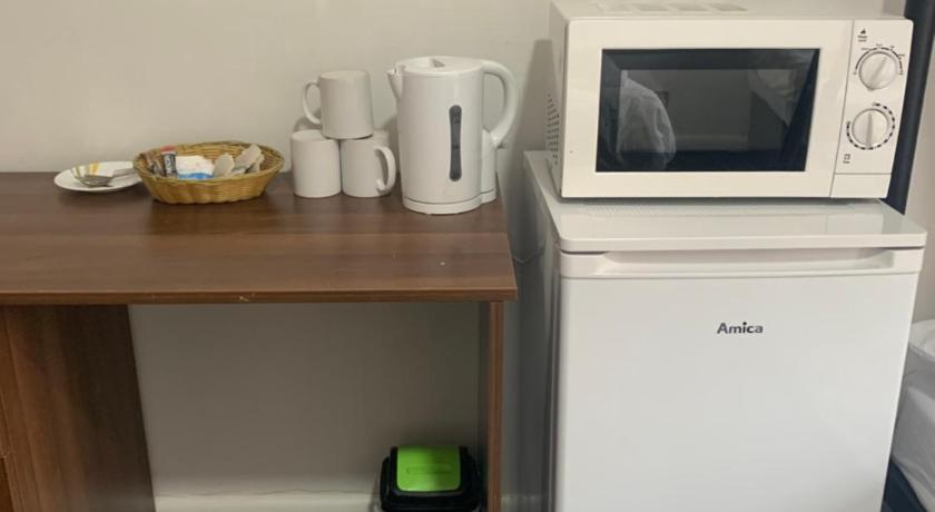 a kitchen with a microwave and a cupboard, Hagley Hotel in Birmingham