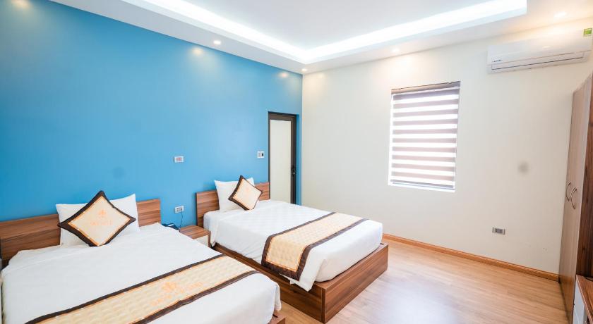 a bedroom with two beds and two windows, Sky hotel in Uong Bi